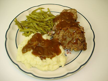 a meal of meatloaf, potatoes and green beans
