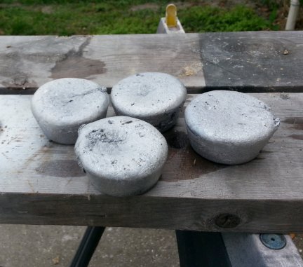 Four newly cast ingots of aluminum.