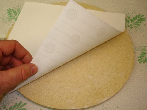 Putting shelf paper on the kiln shelf.