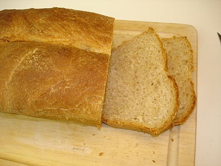 Slicing a loaf of my home-cooked Honey Wheat bread