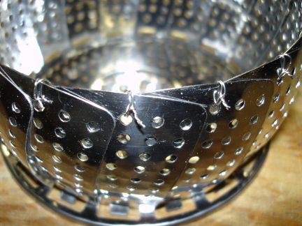 A stainless steel vegetable steamer used as a grate.